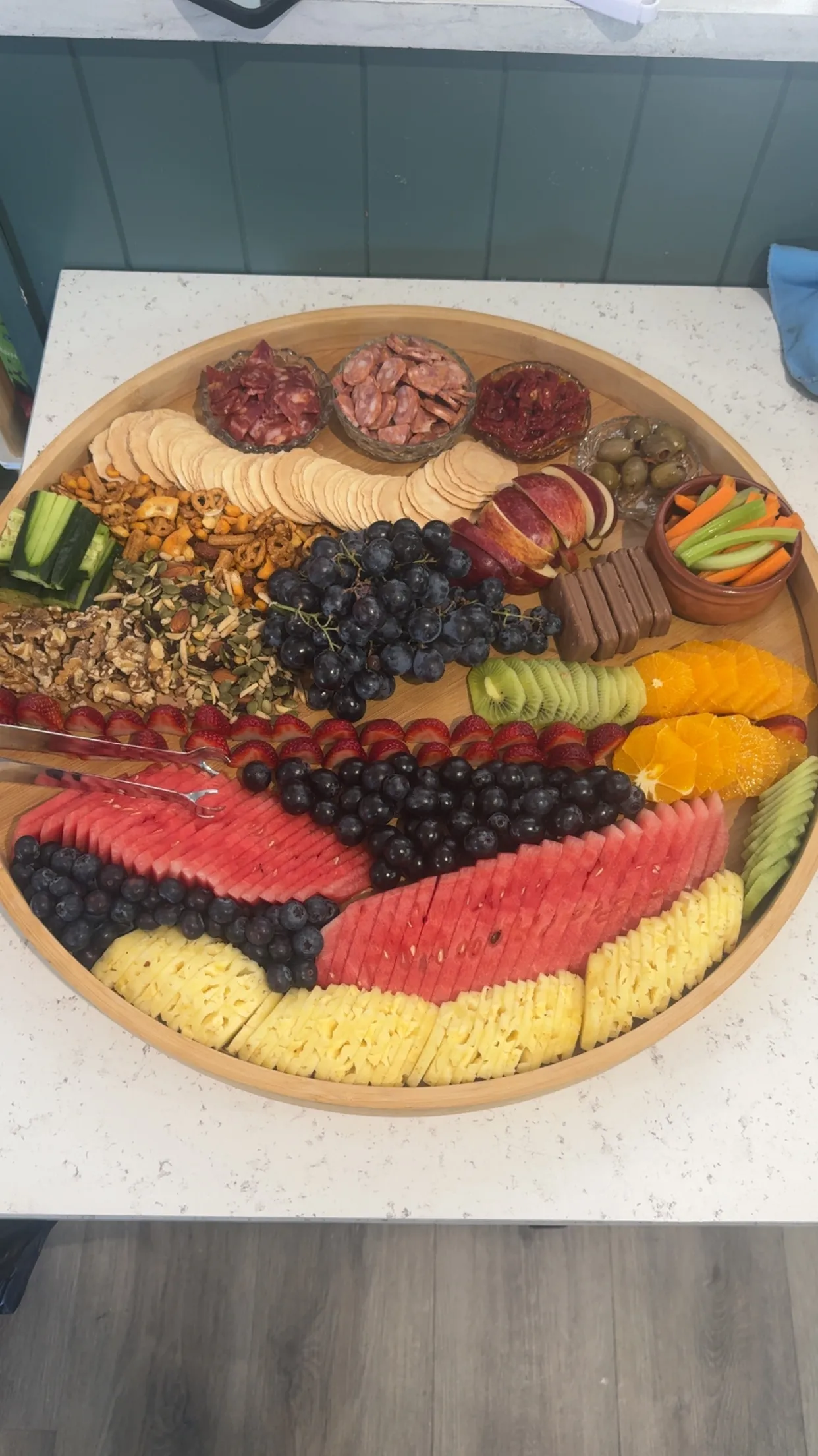 Round board piled with watermelon, pineapple, grapes and orange slices