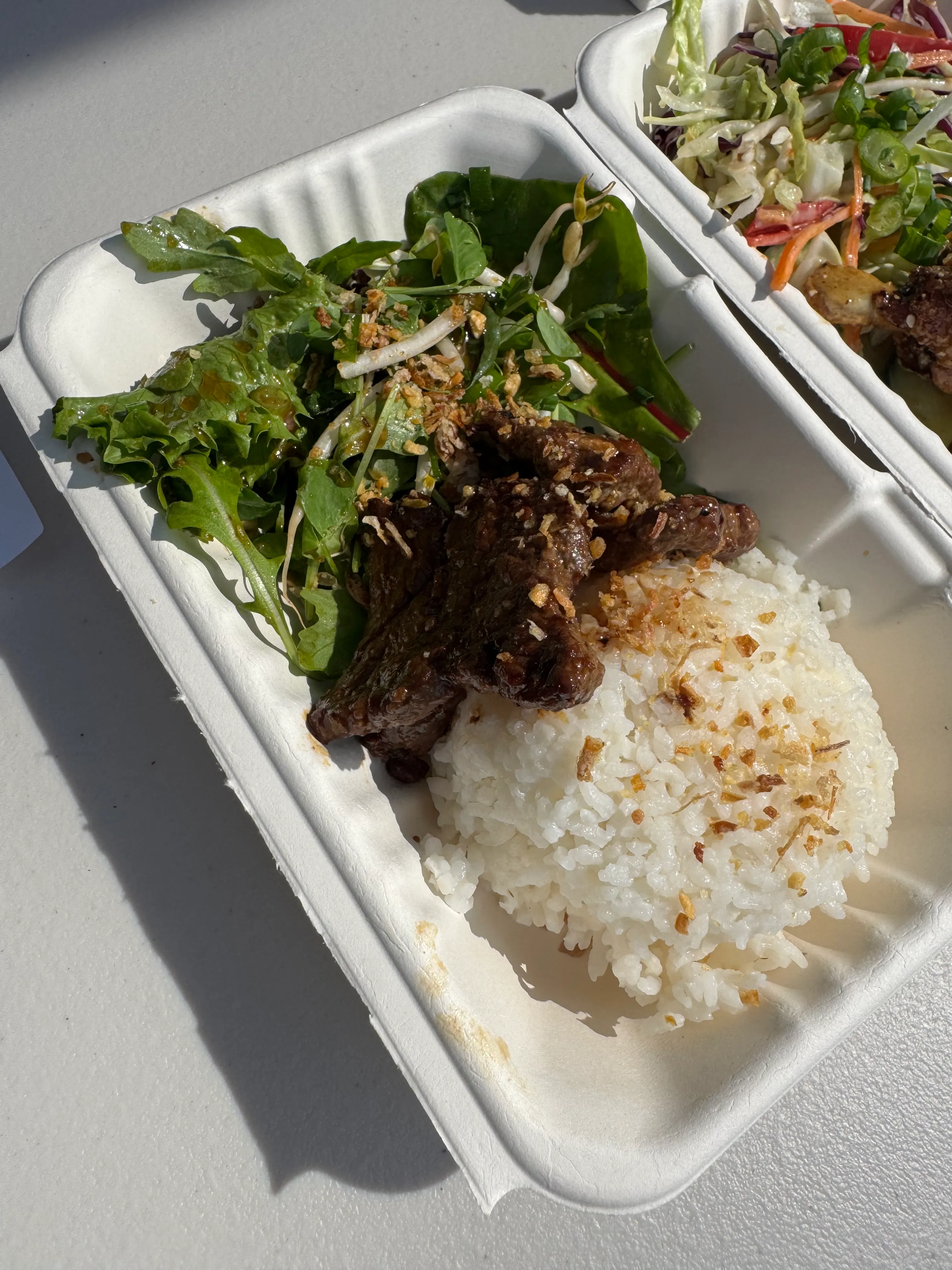 Jasmine rice and Asian-braised beef strips in a takeaway box