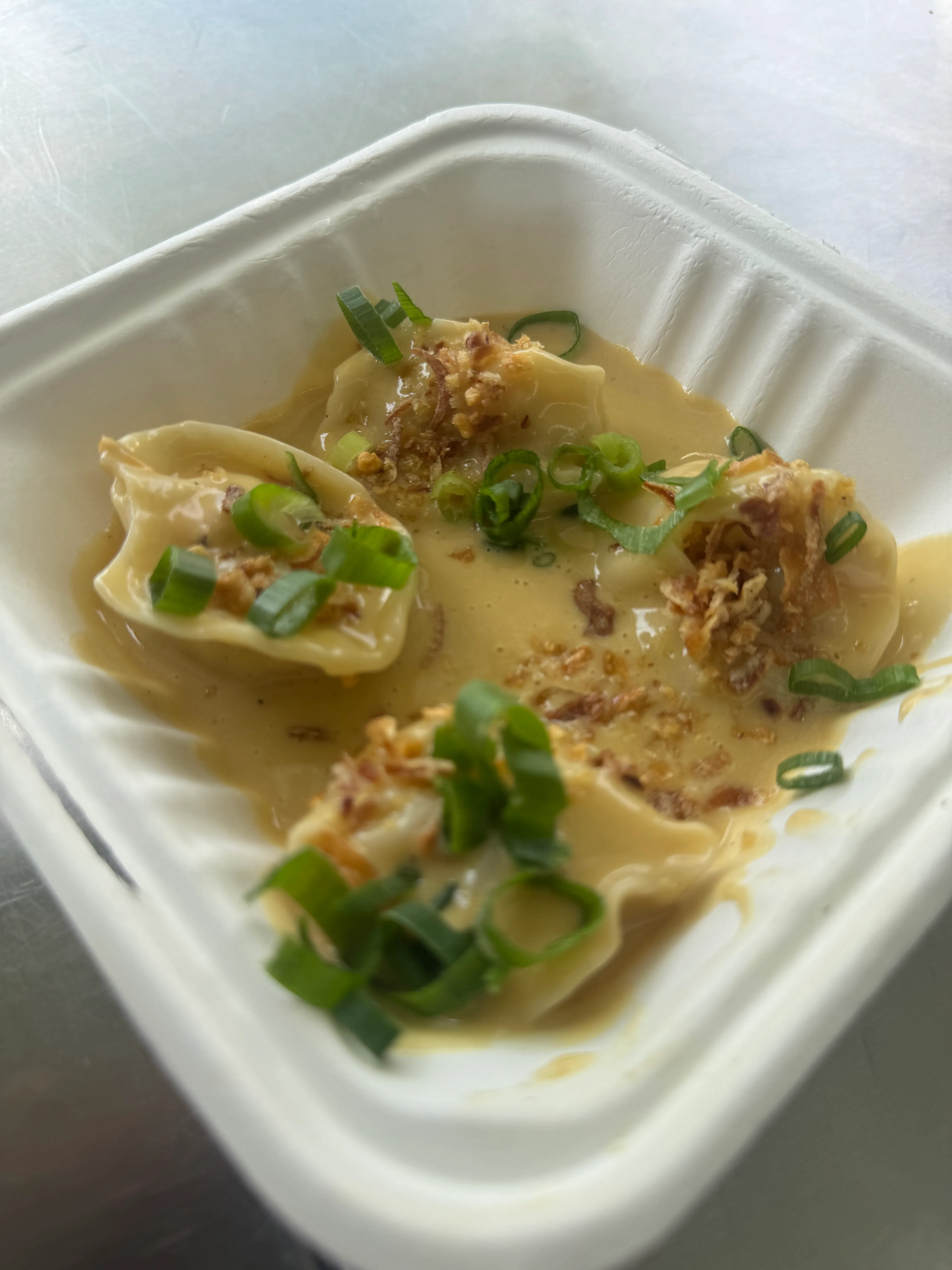 Four steamed wontons in broth with spring onion and crispy shallots