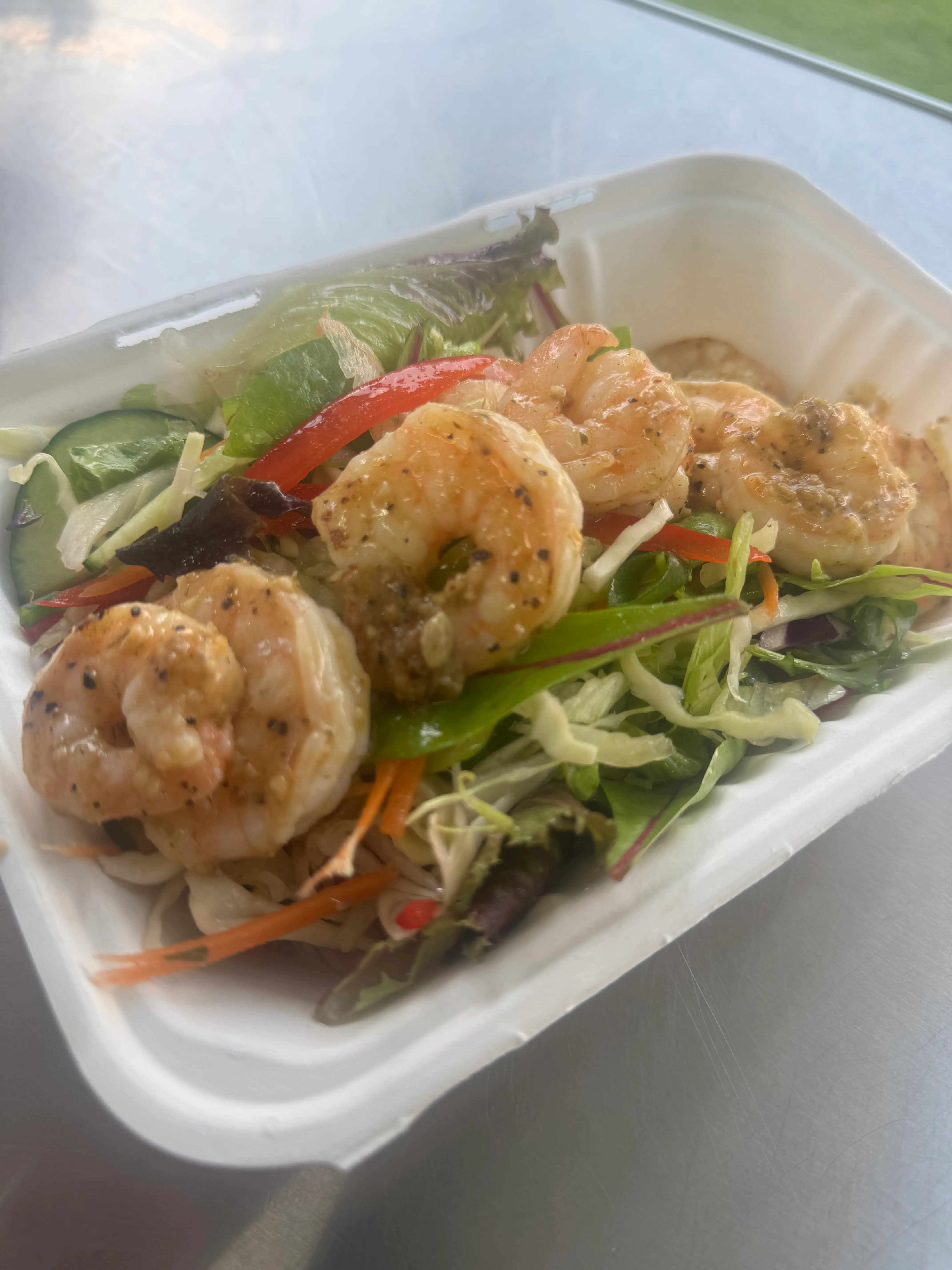 Grilled prawns on mixed greens with capsicum and cucumber