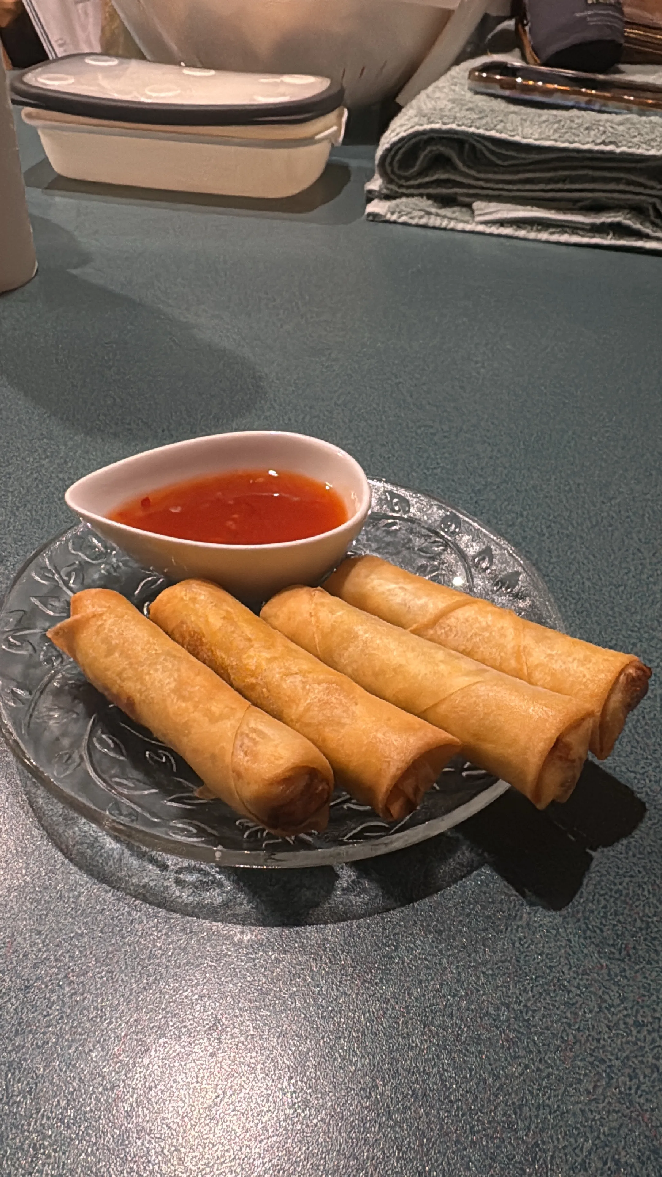 Crispy spring rolls on a glass plate with sweet chilli dipping sauce